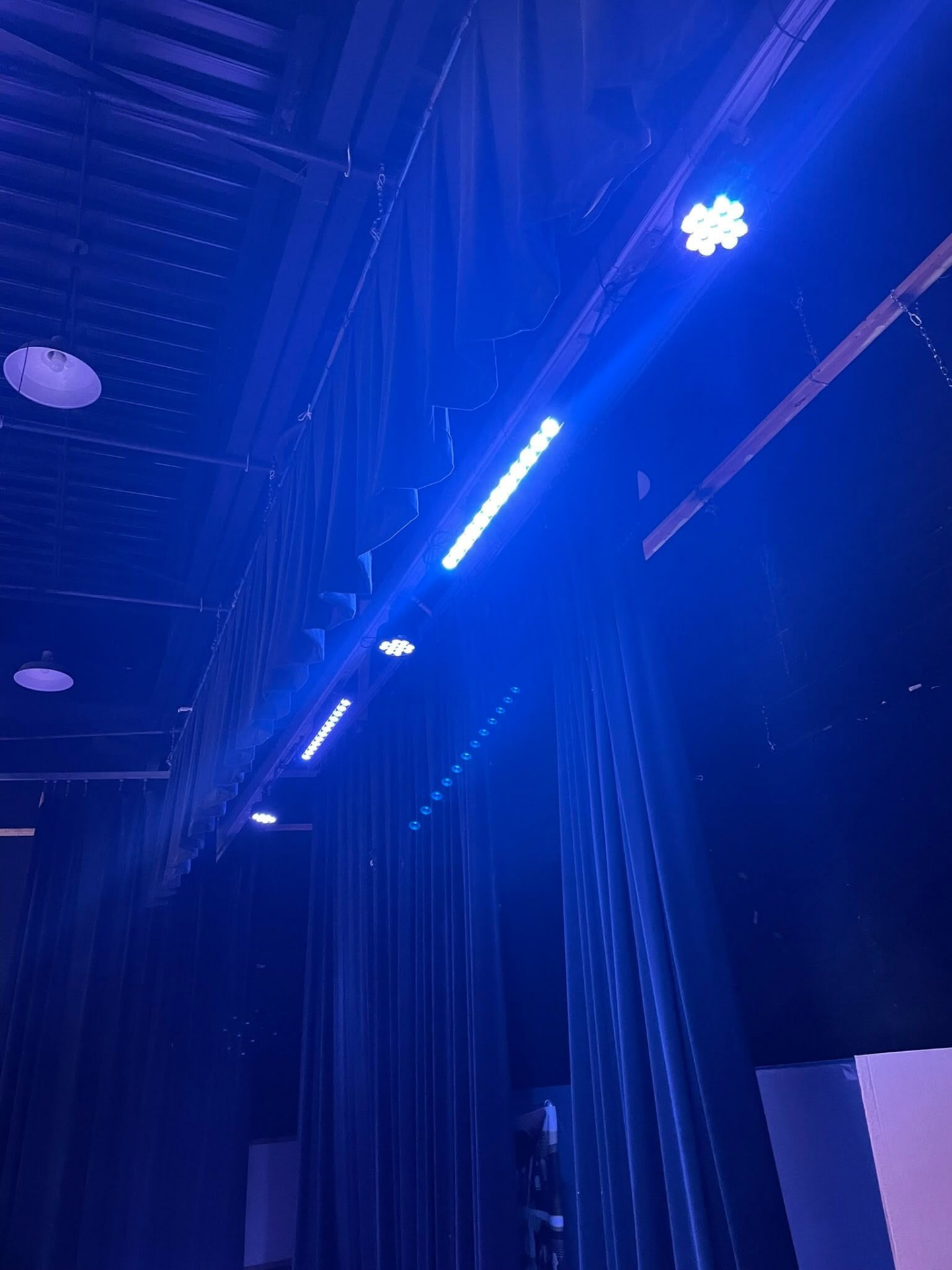 Blue LED stage lights operating above an auditorium stage in Chickasaw County
