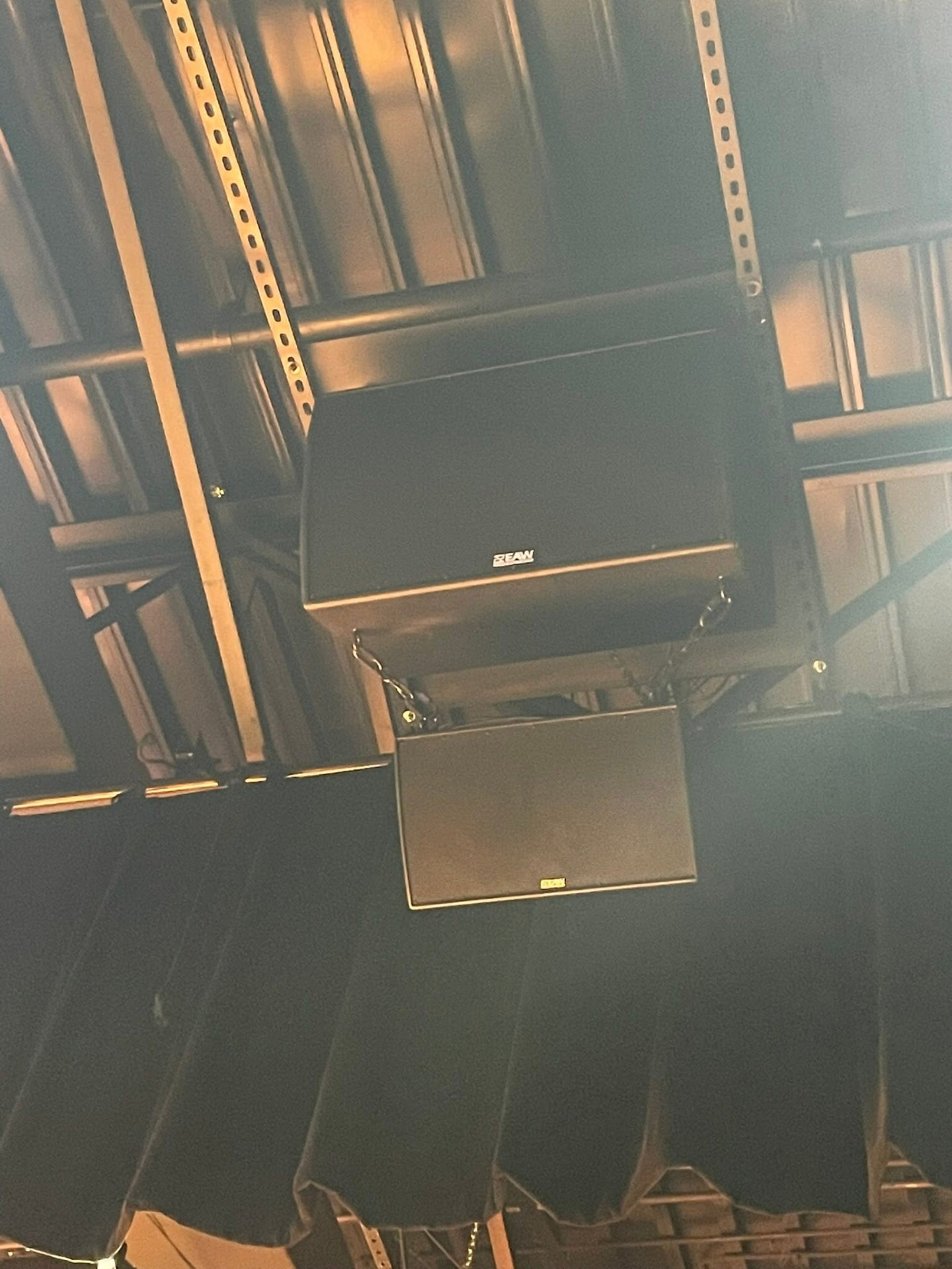 Installed auditorium speakers mounted above a stage